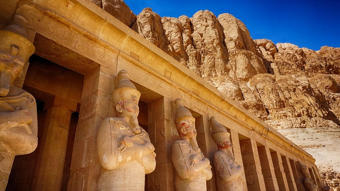 he Osirid statues and limestone colonnades of the Mortuary Temple of Hatshepsut at Deir el-Bahari, Luxor, during a private Top Class Egypt Travel excursion.