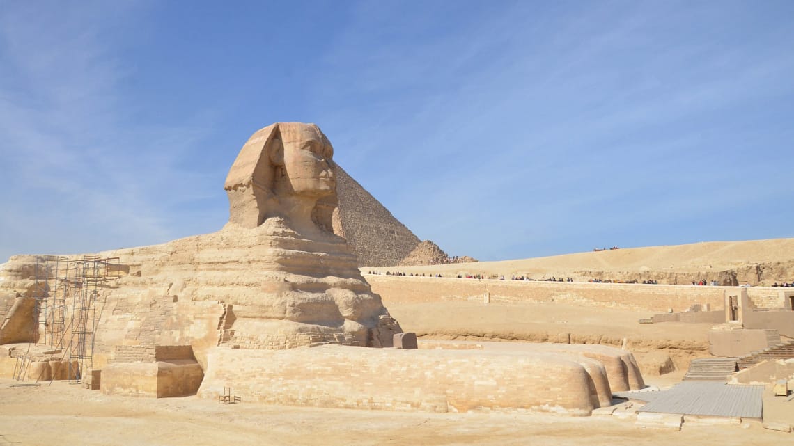 A side profile of the Great Sphinx of Giza with a pyramid in the background, visited during a private, expert-guided tour with Top Class Egypt Travel.