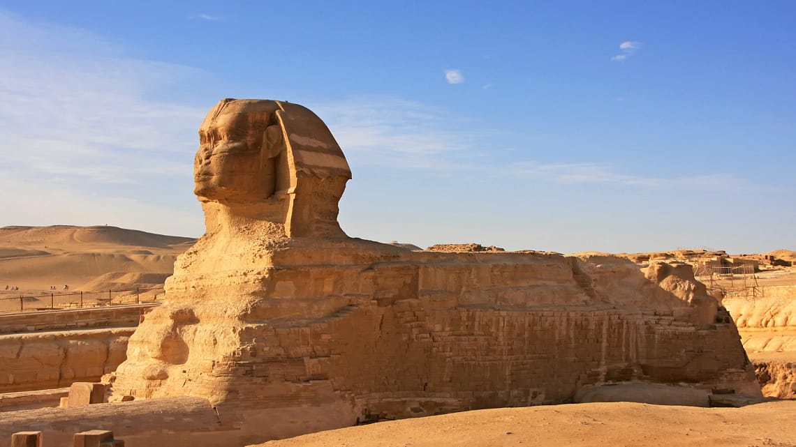 Side view of the Great Sphinx of Giza with a clear blue sky background