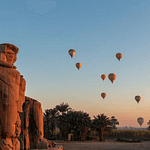 Colossi of Memnon at dawn with hot air balloons in the sky Luxor Egypt.jpg