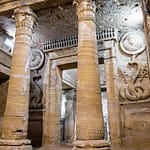 Underground stone pillars and carved reliefs inside the ancient Catacombs of Kom El Shoqafa in Alexandria, Egypt.