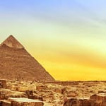 The Great Pyramid of Khufu at Giza illuminated by a golden sunset sky, showcasing the ancient limestone structure in Cairo, Egypt.