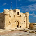 The historic stone walls and fortress of Qaitbay Citadel overlooking the Mediterranean Sea in Alexandria Egypt.