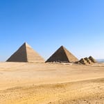 A wide-angle view of the Giza Pyramid complex under a bright blue sky, a primary destination for private day trips from Hurghada with Top Class Egypt Travel. - Cairo Day Trip from Hurghada