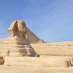 A side profile of the Great Sphinx of Giza with a pyramid in the background, visited during a private, expert-guided tour with Top Class Egypt Travel.