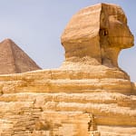 A side profile of the Great Sphinx of Giza with a pyramid in the background, visited during a private, expert-guided tour with Top Class Egypt Travel.