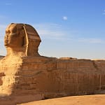 Side view of the Great Sphinx of Giza with a clear blue sky background