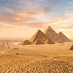 Panoramic view of the Great Pyramids of Giza and the Sphinx during a luxury sunset tour in Egypt.
