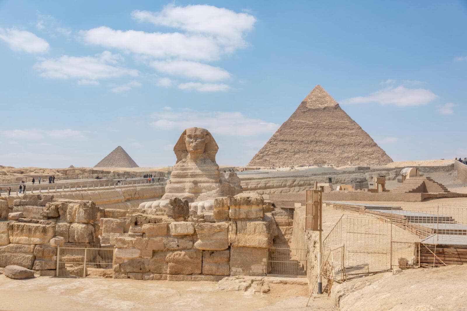 The Great Sphinx of Giza with the Great Pyramid of Khufu in the background under a clear blue sky, Cairo, Egypt.