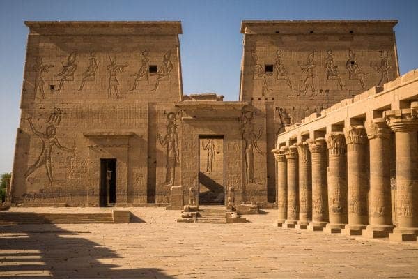 The grand entrance of Luxor Temple at sunset, featuring the ancient pylon, towering columns, and an obelisk in the heart of Luxor, Egypt.