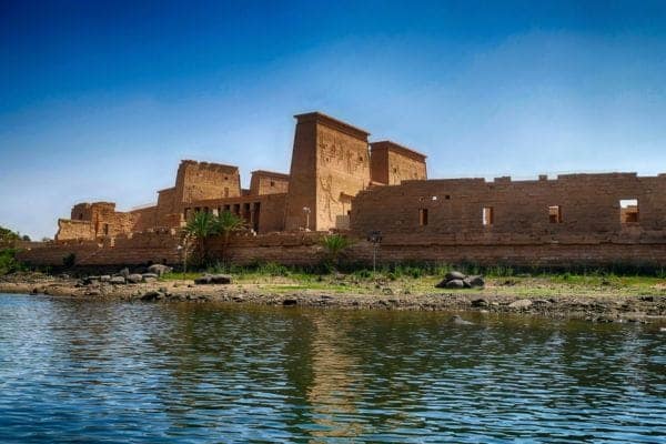 The ancient Philae Temple complex dedicated to the goddess Isis, reflected in the waters of the Nile on Agilkia Island, Aswan- Luxury Egypt Tour